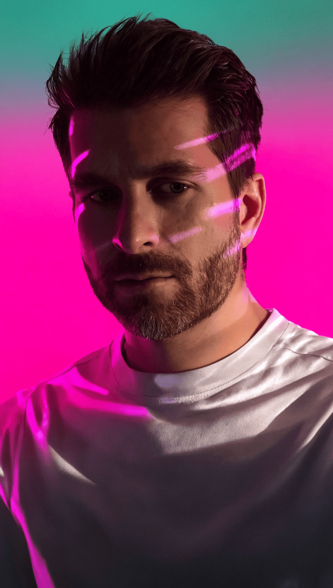 A thoughtful young person with dark hair gazes to the side, captured in soft black and white lighting.