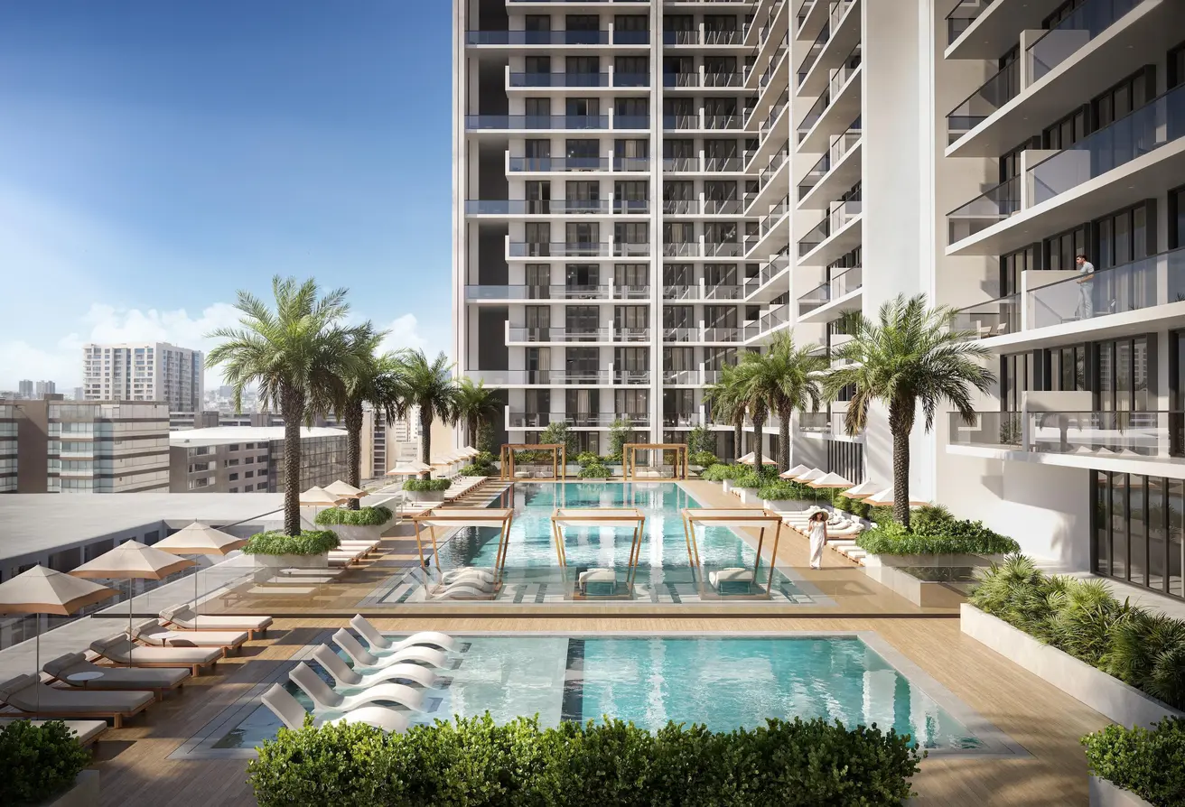 Resort-style pool area with palm trees and sun loungers at Binghatti Amberhall in Dubai