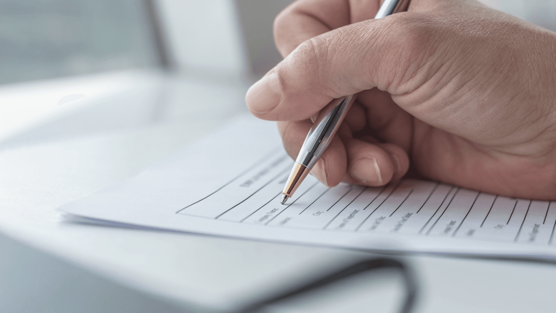 Nahaufnahme einer Hand, die einen Stift hält und in ein Notizbuch schreibt, das mit Notizen oder Listen gefüllt ist.