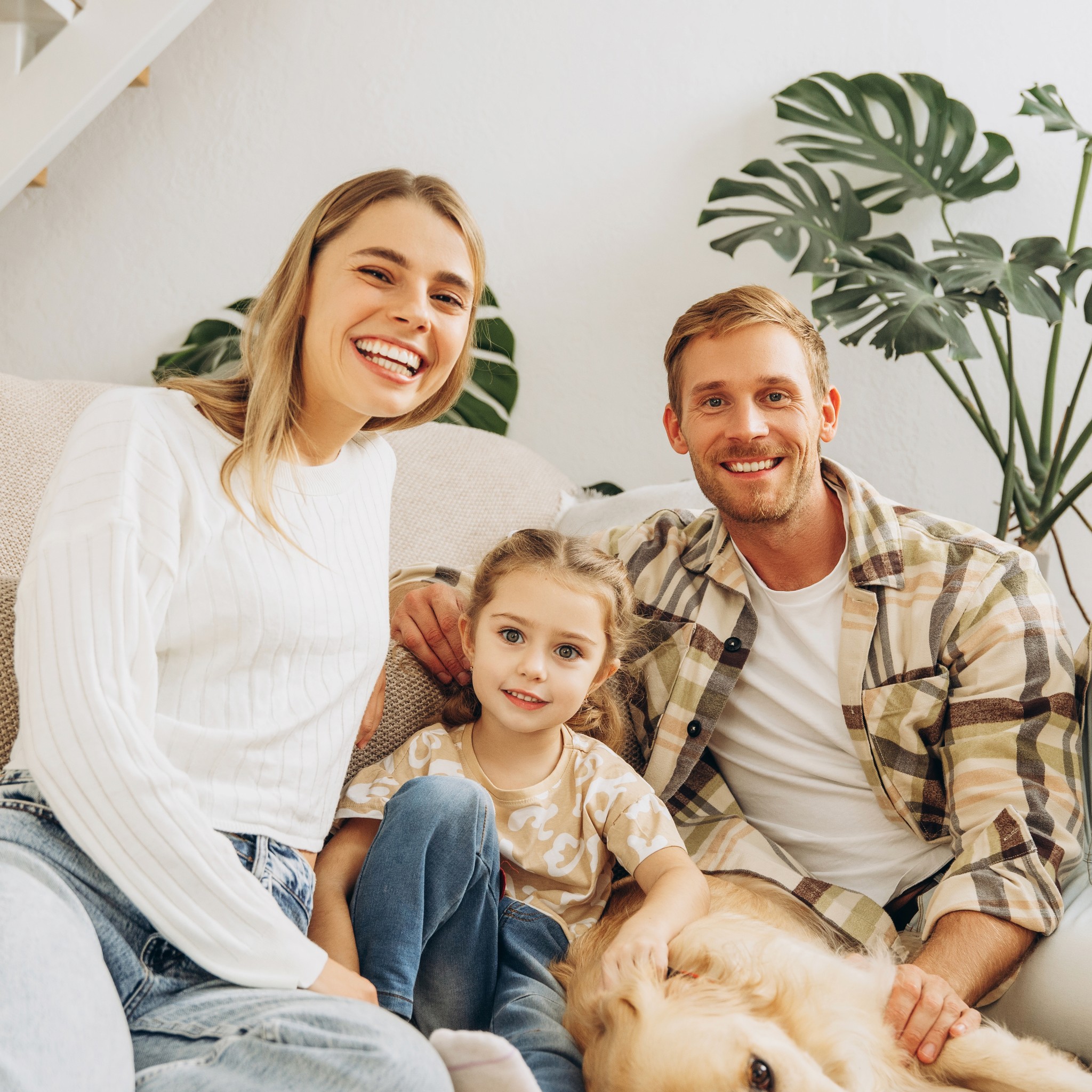 Ema ja isa koos väikse lapse ja koeraga.