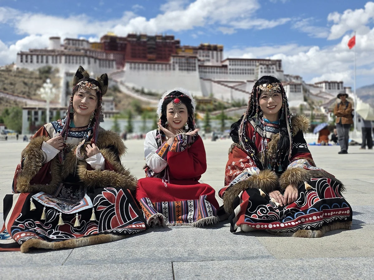 Frauen in Tracht vor einem Tempel