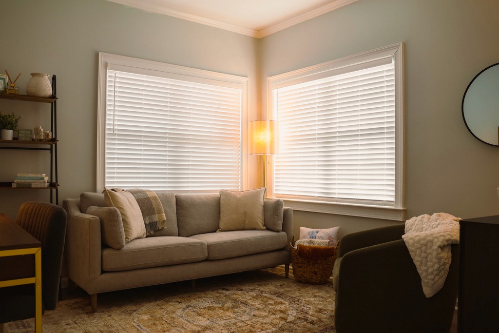 Counseling room with sofa, corner lamp, and window blinds letting in soft daylight.