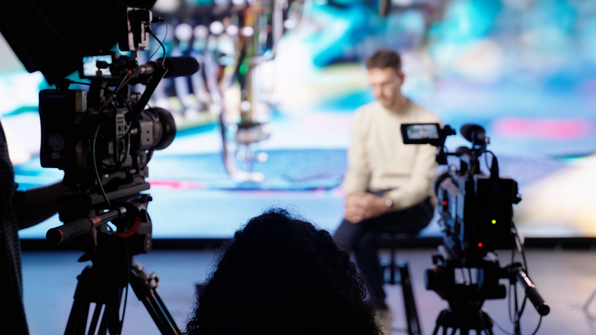 Helpdesk Imagefilm, blurred Behind the Scenes image with camera and light setup