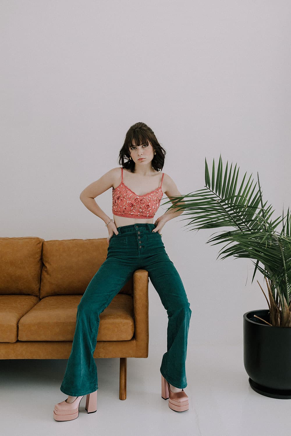 Woman sitting on armrest of couch