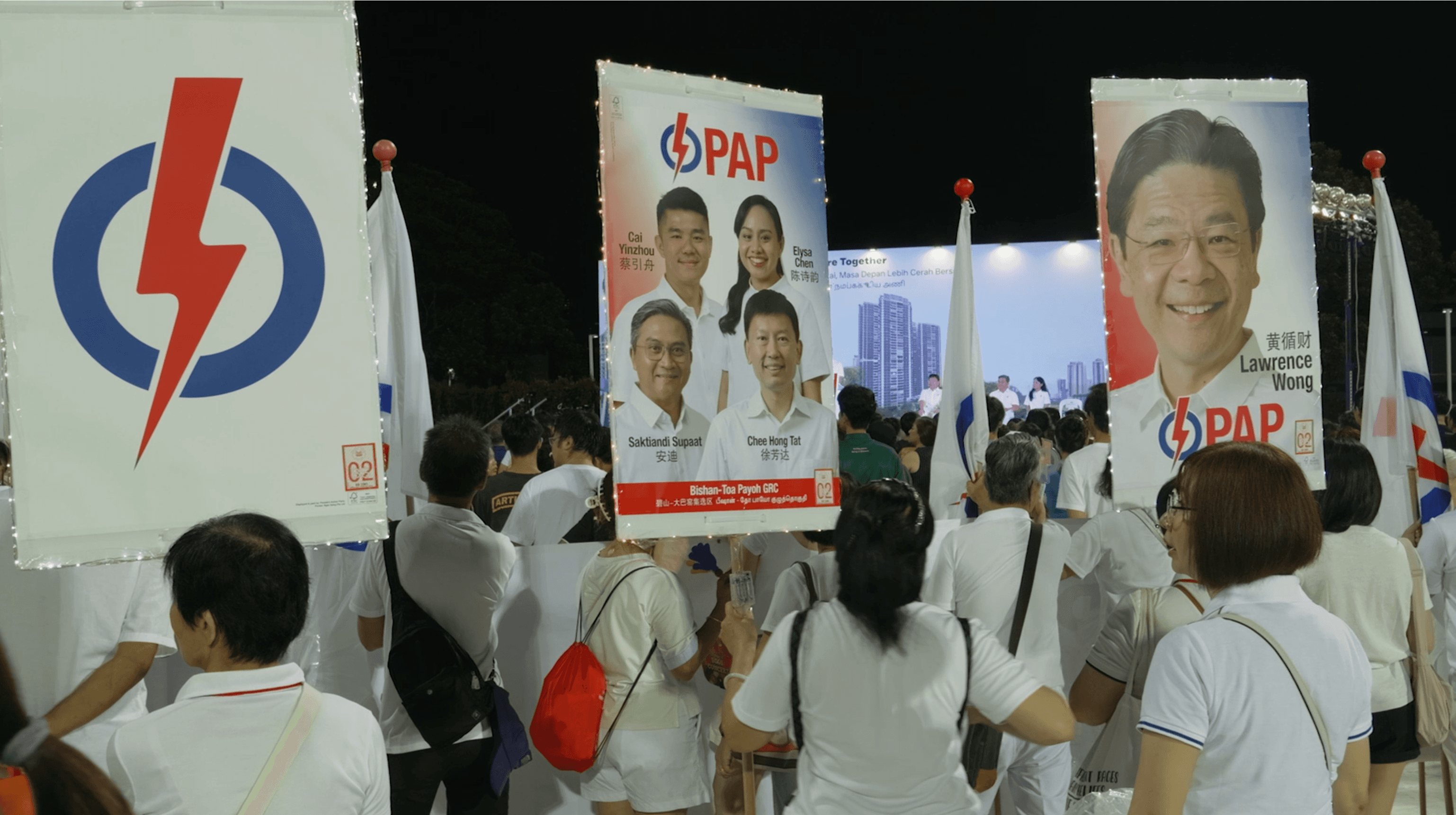 man in black polo shirt wearing white mask holding black camera