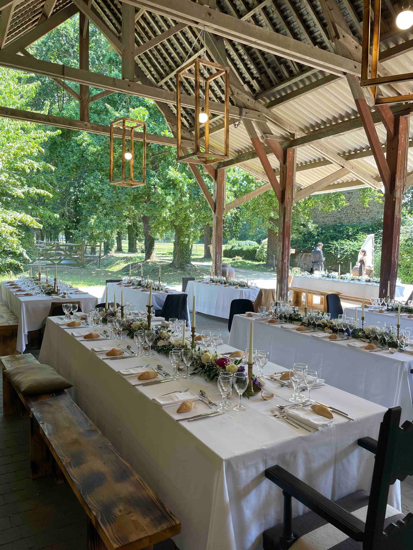 A beautifully set dining table with white tablecloth, cutlery, and fresh greenery in a cozy, well-lit space.