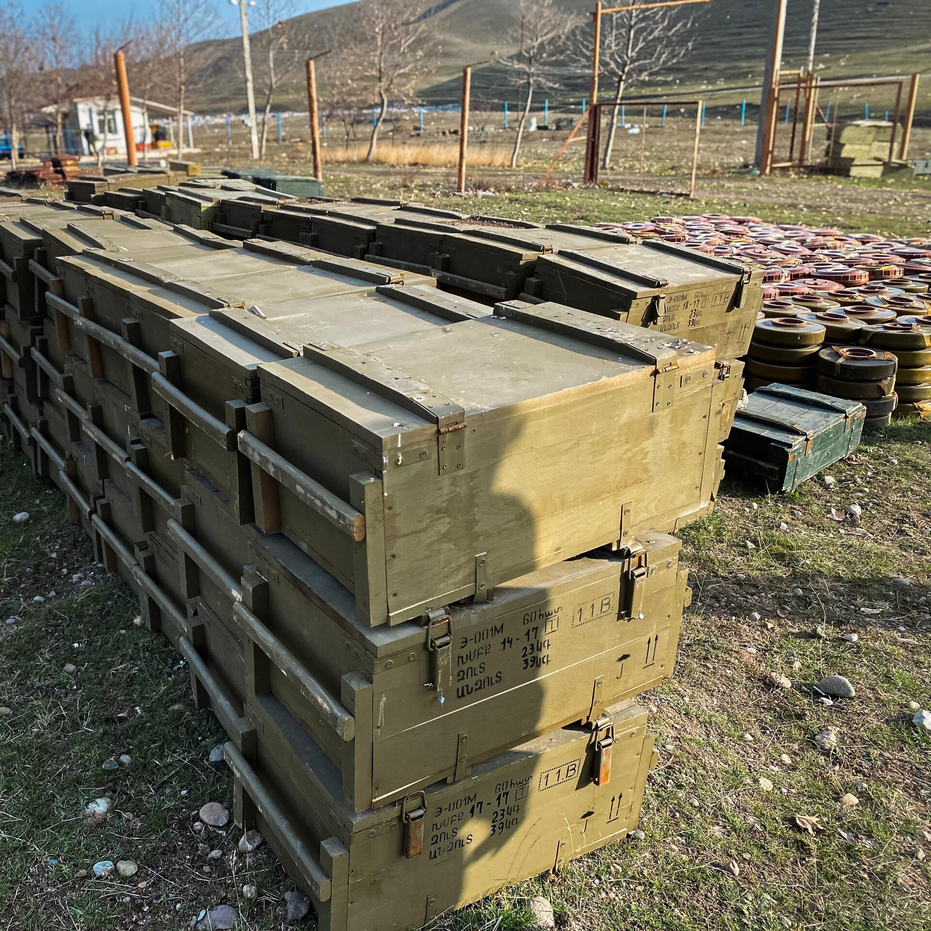 Stacked military ammunition crates and recovered anti-tank mines awaiting disposal during GCS ammunition management operations.