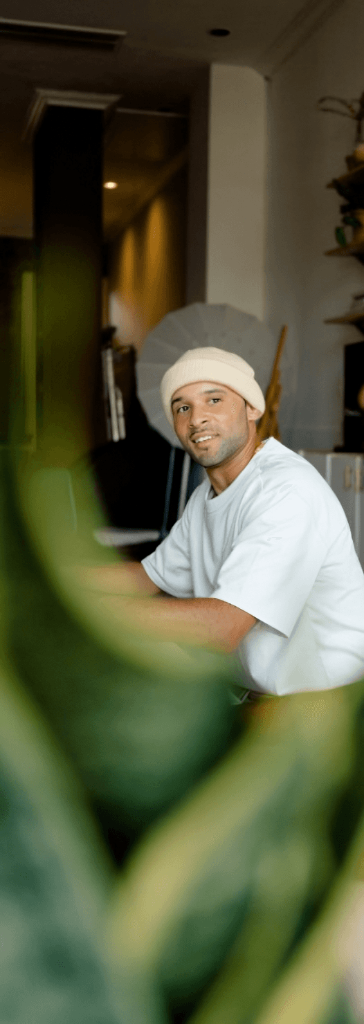 Portrait of a laughing person with curly hair wearing a white shirt