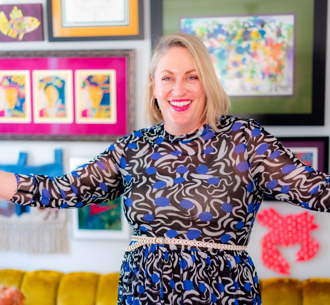 woman in colorful dress standing in front of a gallery wall