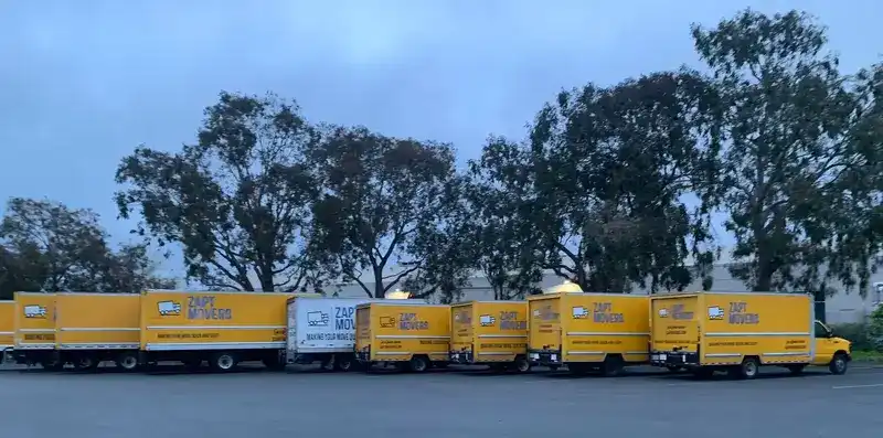 Zapt Movers fleet of yellow moving trucks lined up and ready for service