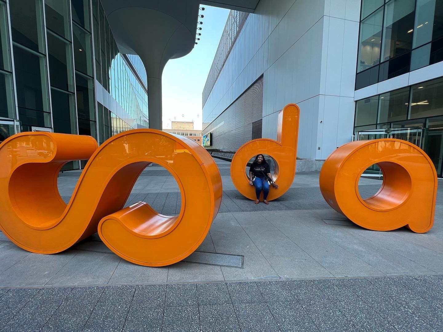 A close-up of a pink cocktail in a martini glass, set against a nighttime background with soft, blurred colors.