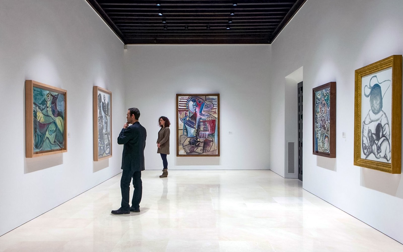 Visitors viewing paintings at Picasso Museum in Malaga.