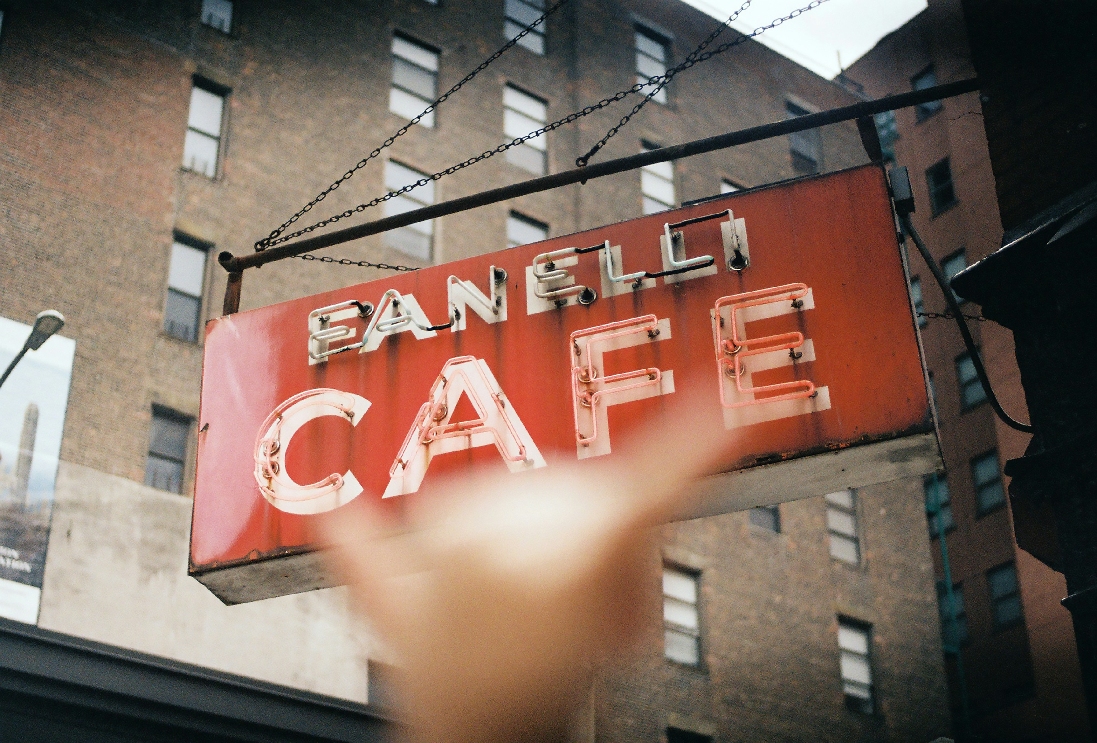 Hand gestures at the panelli cafe sign.