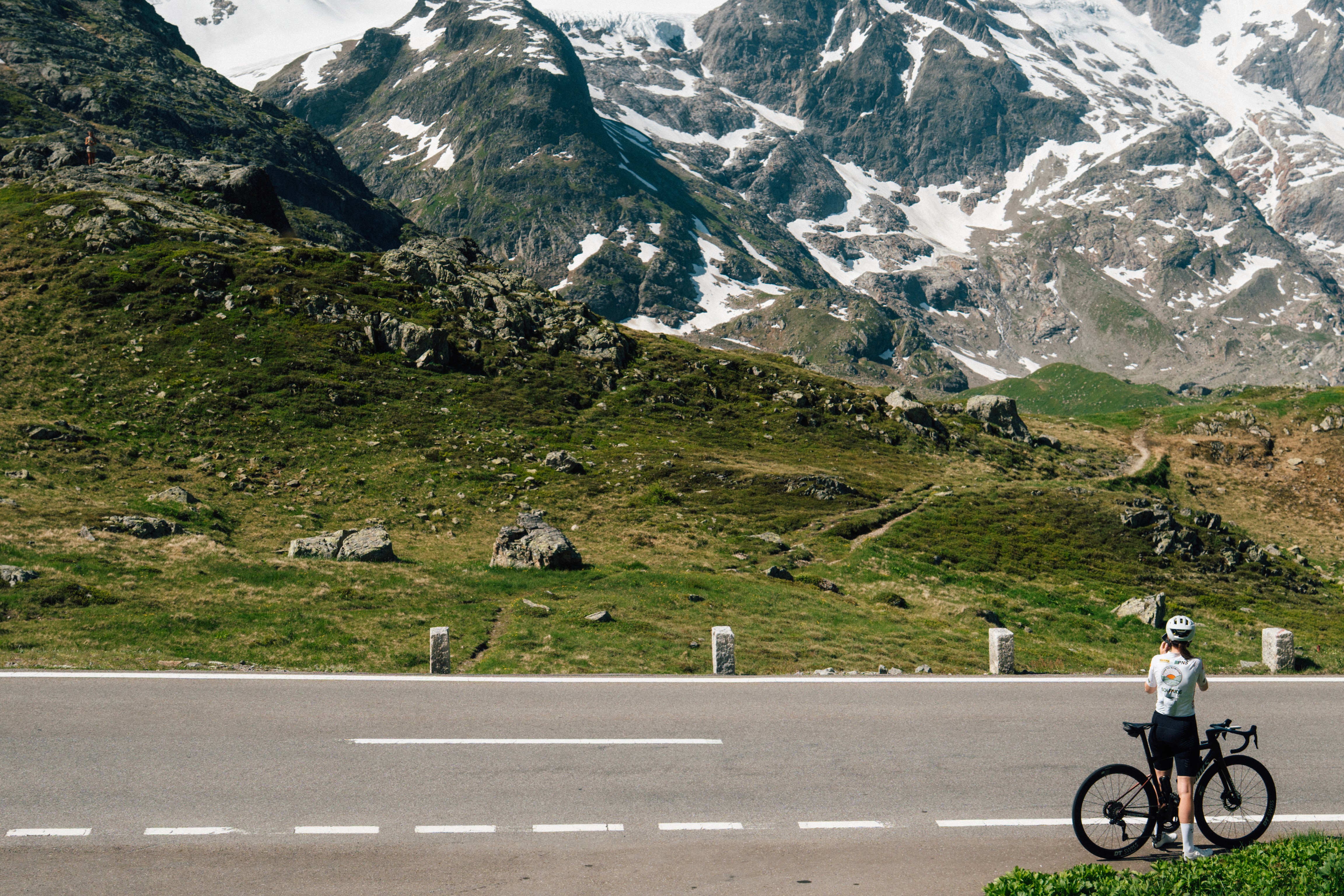 Cyclist stopping to take a photo at the top of the Susten Pass in Switzerland