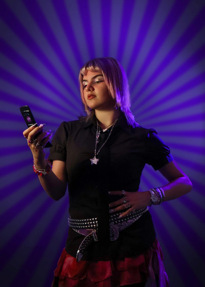 portrait of girl holding Y2K phone, striped background