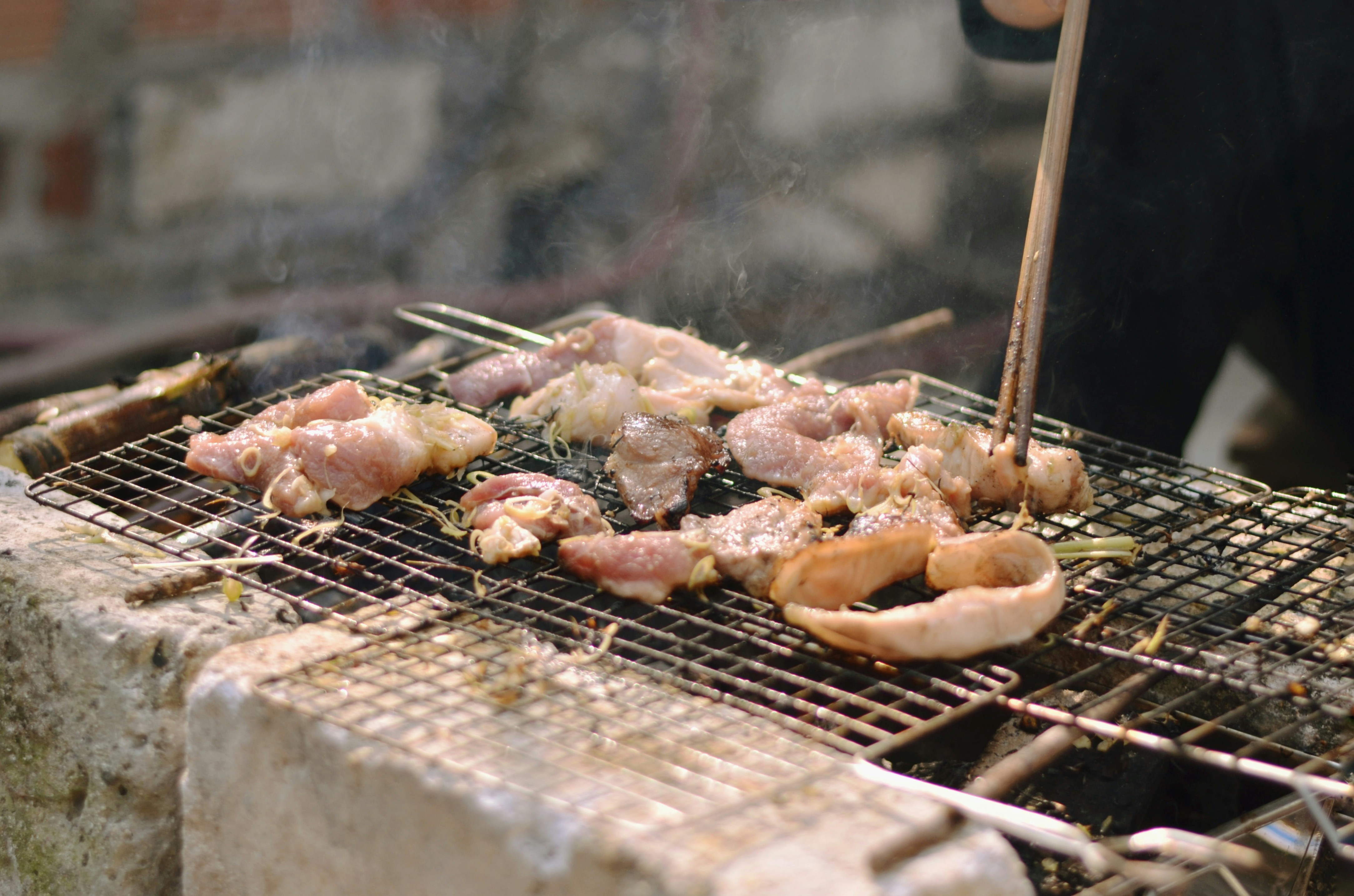 A person cooking food on a grill outside
