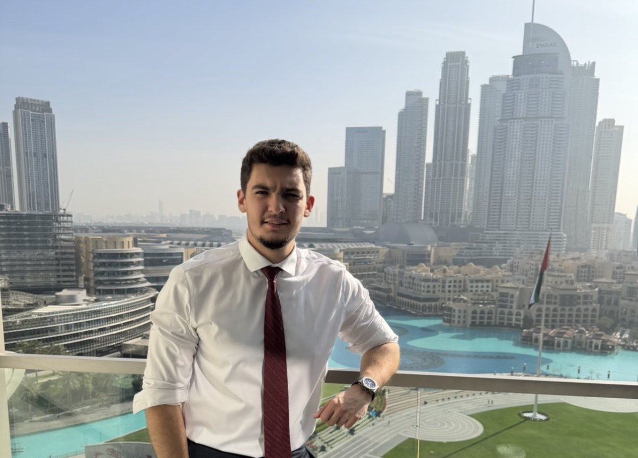 man in black suit jacket holding white ceramic mug