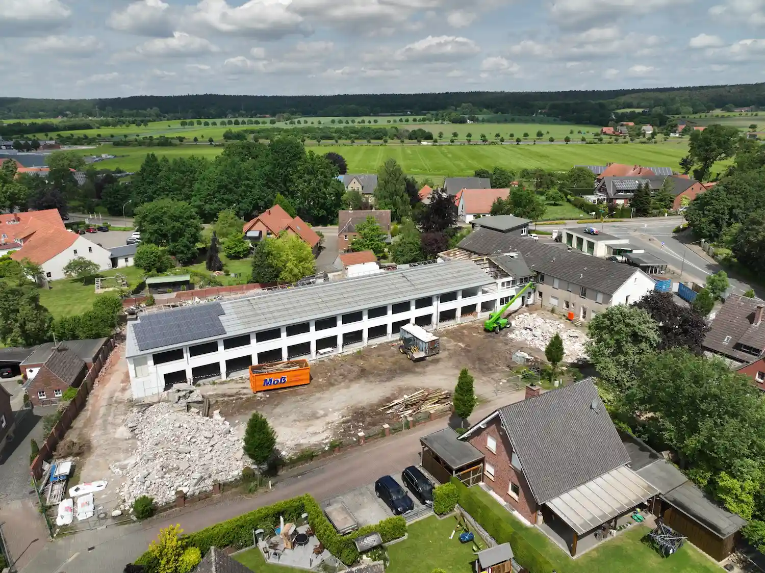 Isometrische Zeichnung eines Bauprojekts mit mehreren Gebäuden und markierten Strukturen in Rot