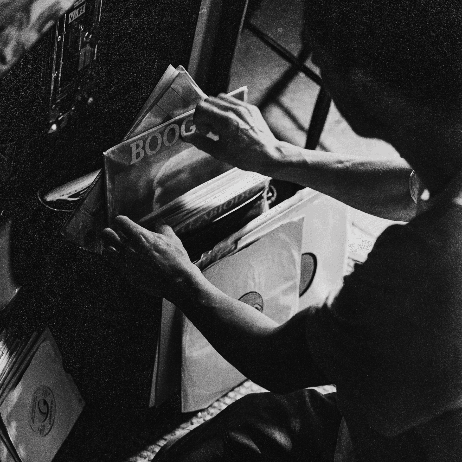 Over the shoulder shot of a figure looking through a stack of records