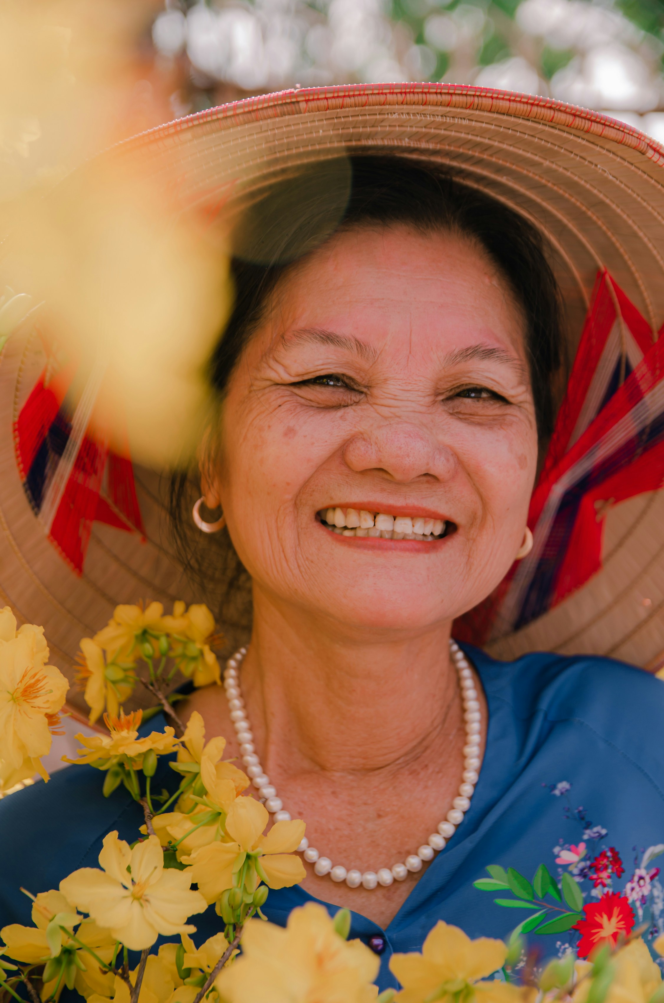 a woman wearing a hat with flowers around her neck