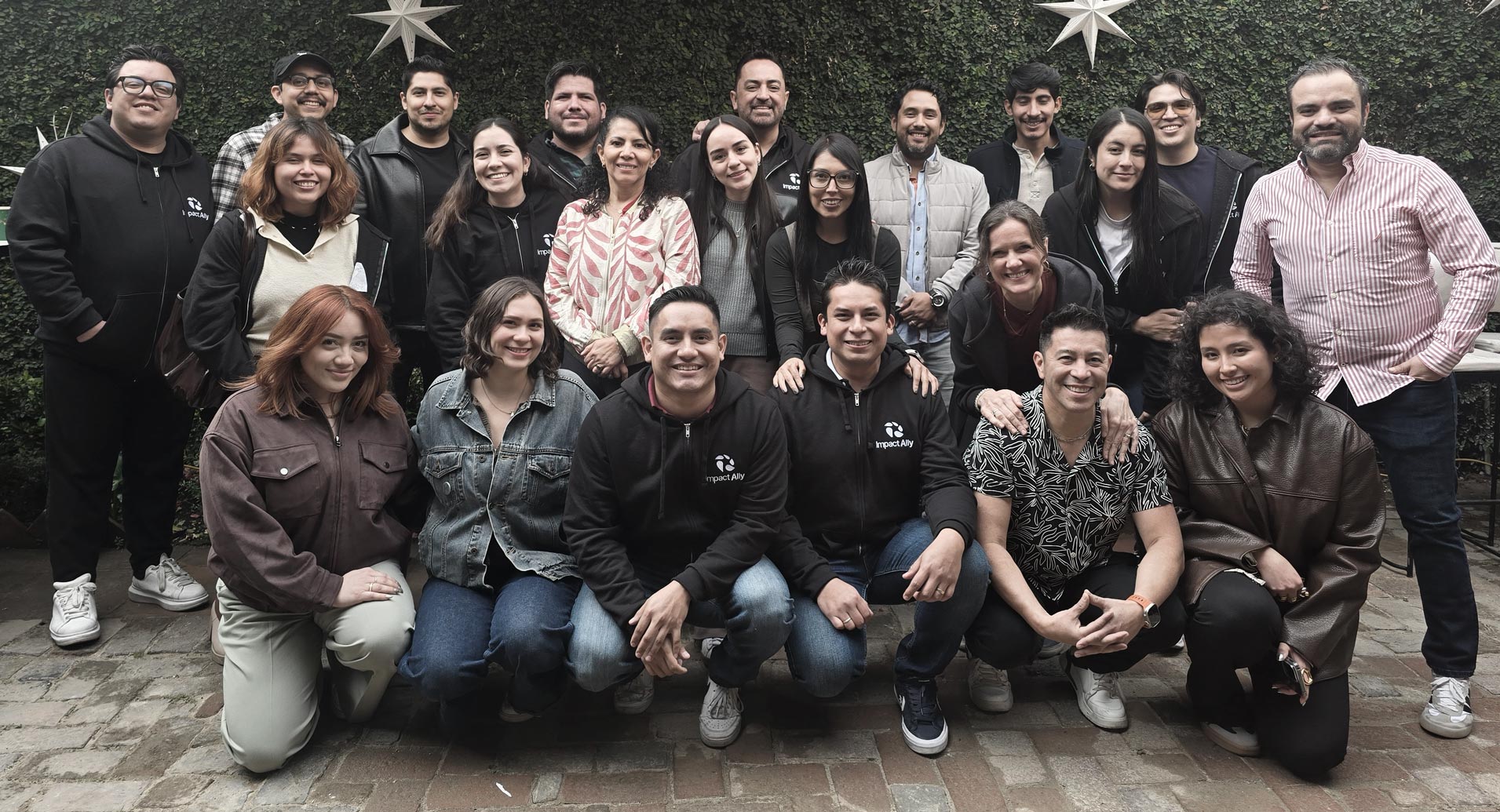 Black and white image of people working at a table with laptops, showing hands gesturing during discussion of digital content displayed on screens, with fabrica® logo in the corner.