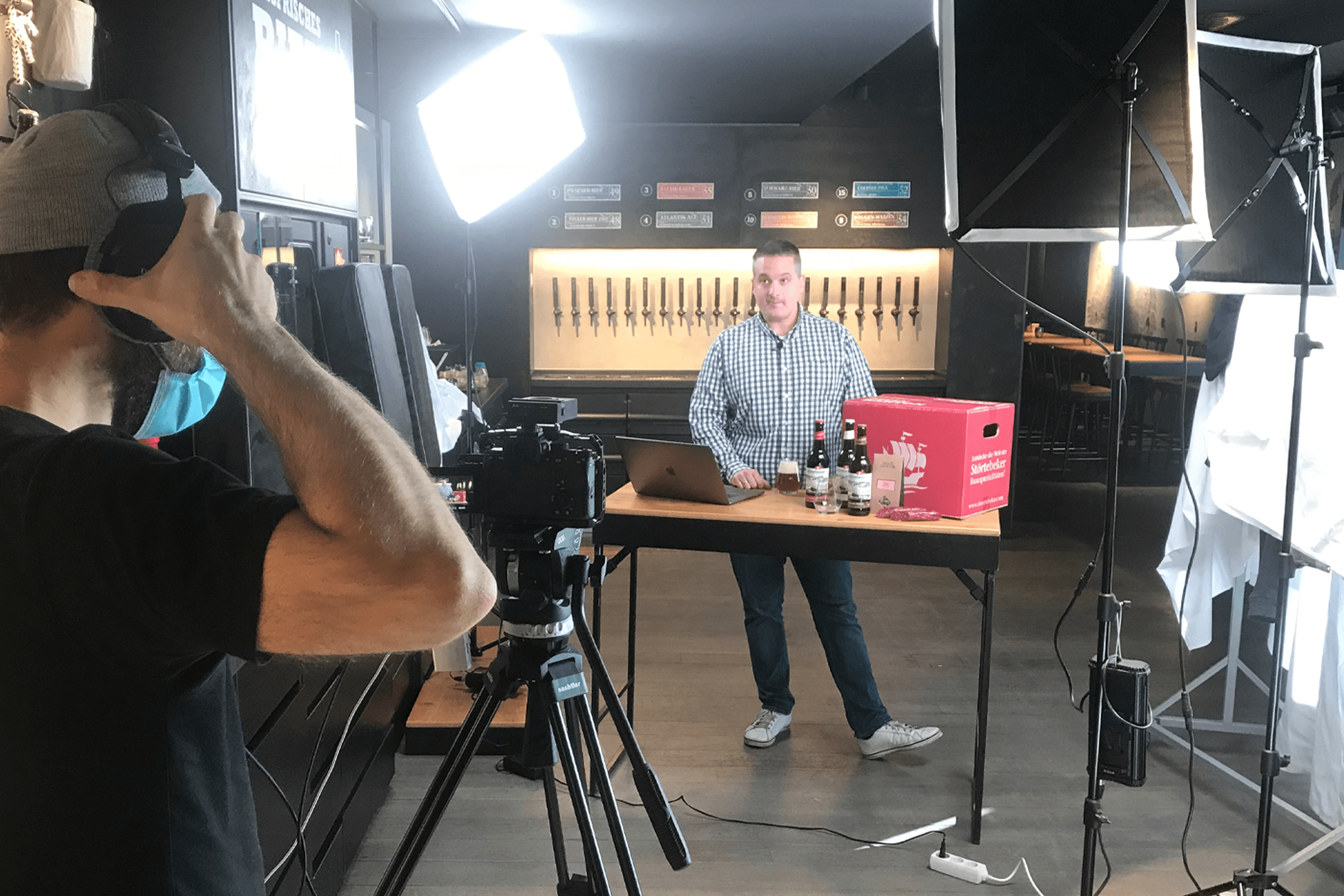 Man filming beer tasting with camera and lighting rig.