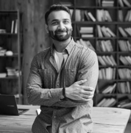 A person stands in a dark space with glowing, circular light patterns in orange and blue hues, creating a surreal and futuristic vibe.