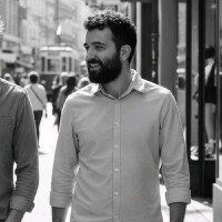 Profile portrait of a man in a white shirt against a light background