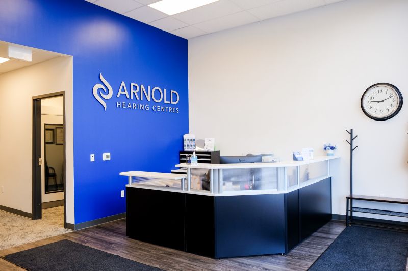 Modern office reception area featuring a sleek desk, blue accent wall, and a wall clock.