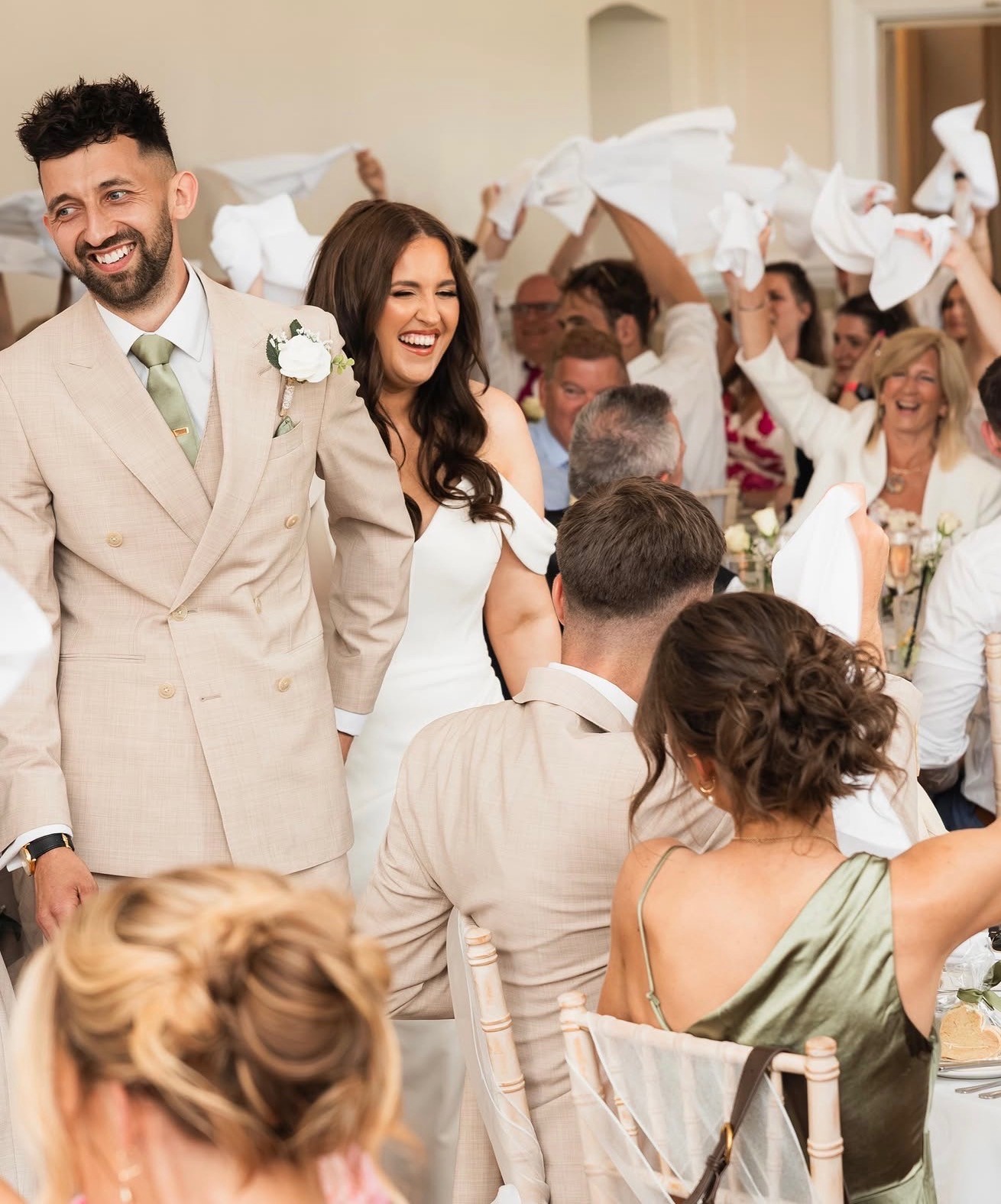 Newlyweds smiling as they enter their reception