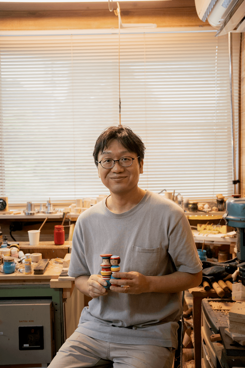 Craftsman holding kokeshi dolls