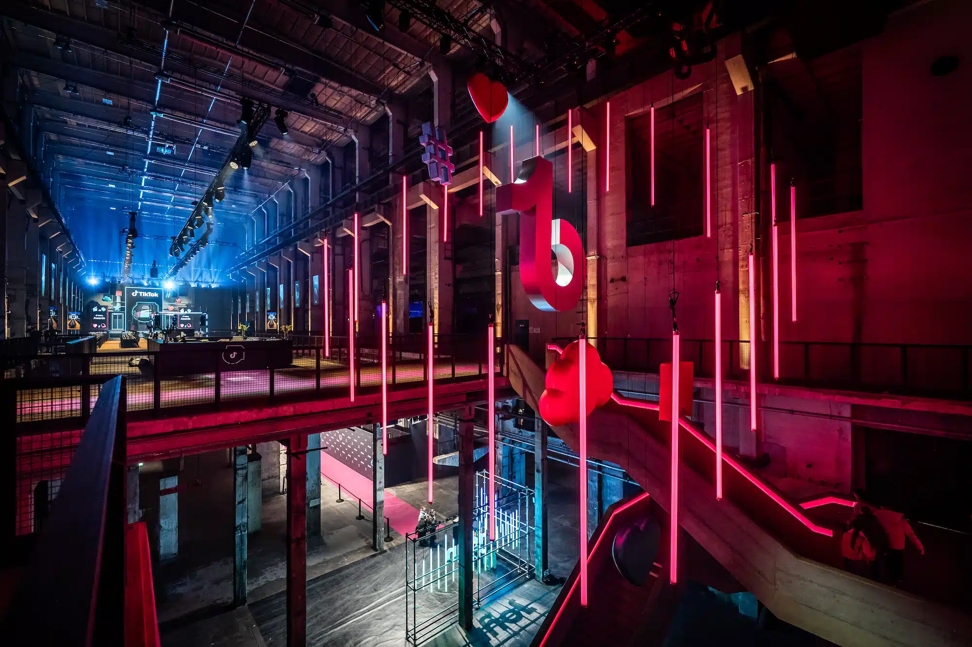 TikTok Awards – industrial event venue with red neon installations, floating hearts and spectacular light architecture