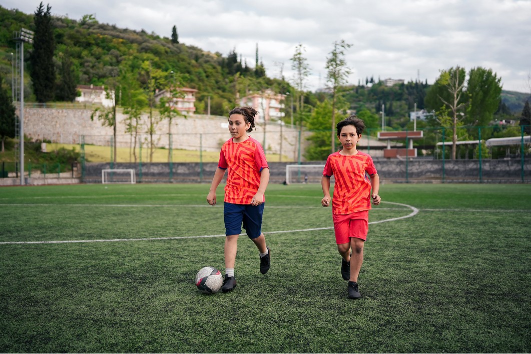 five children smiling while doing peace hand sign