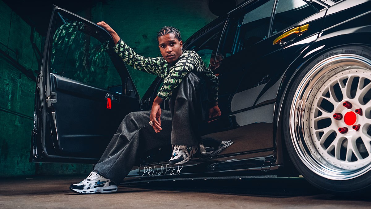 A real photograph of A$AP Rocky leaning against his custom 1988 Mercedes-Benz 190E, showcasing his iconic urban style.
