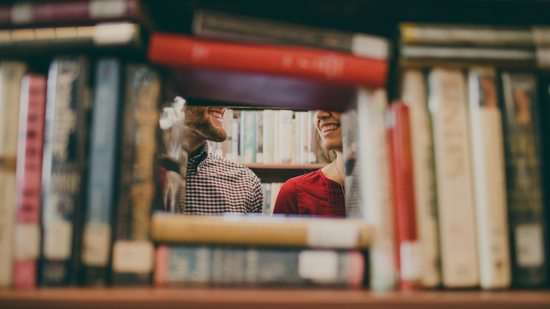 couple smiling with curiosity in the library scripsy