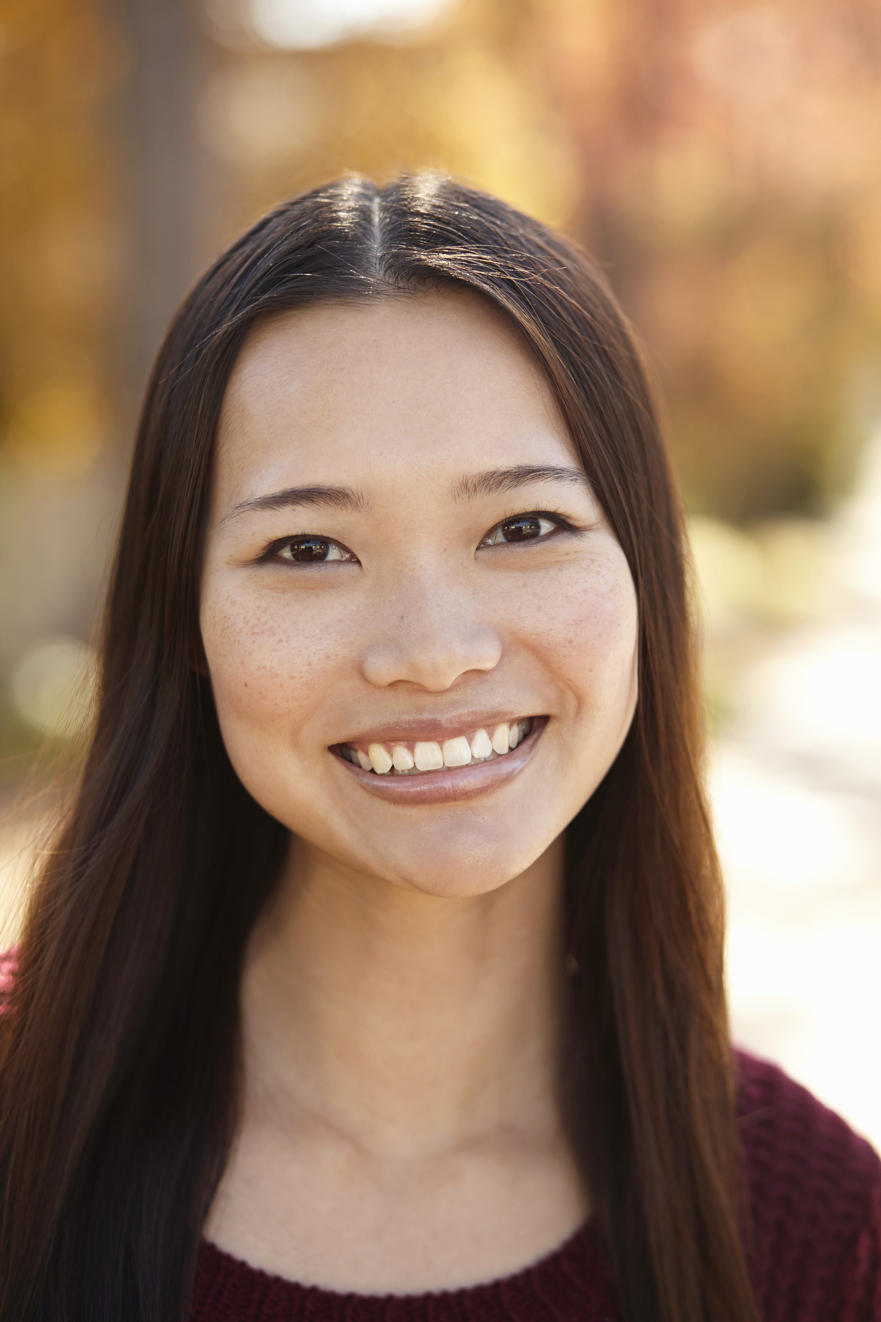 The image features a close-up portrait of a person with short, dark hair and round glasses.