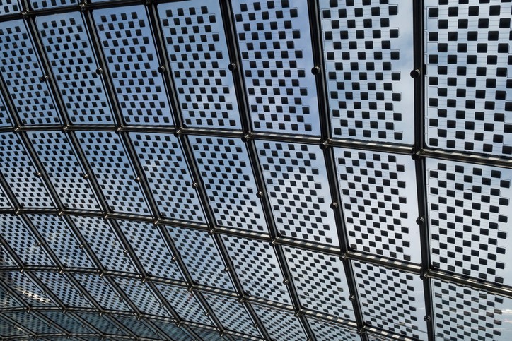 Nahaufnahme eines diagonalen Photovoltaikmoduls, im Hintergrund ist blauer Himmel zu sehen.