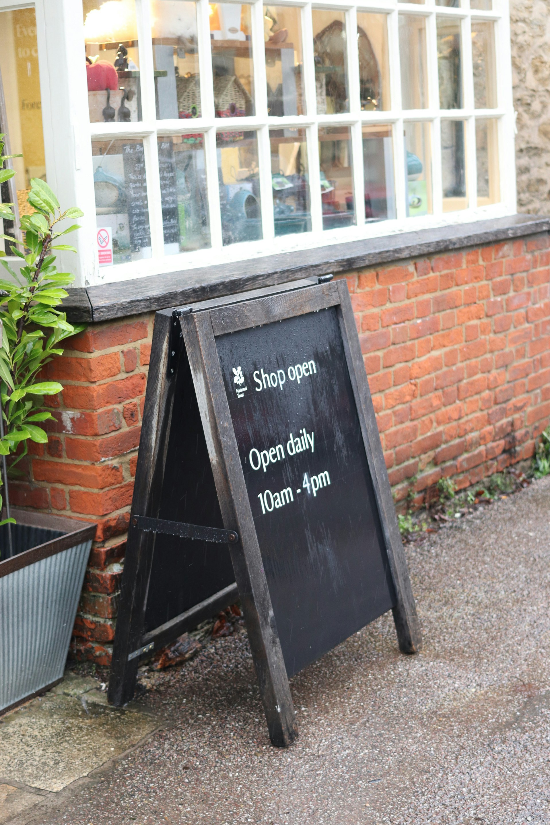 A-frame sign outside a shop showing opening hours.