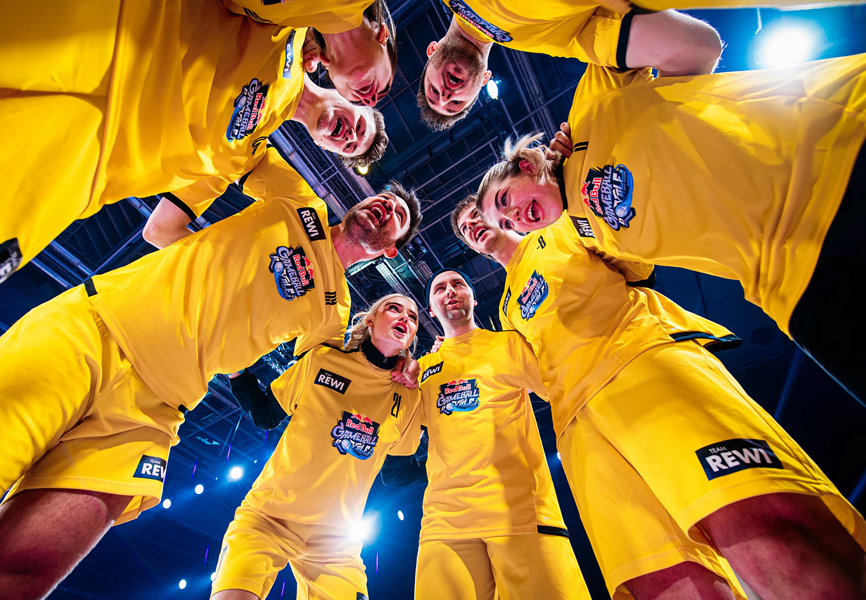 Eventteam in gelben Trikots steht im Kreis zusammen und feuert sich für den Einsatz an.