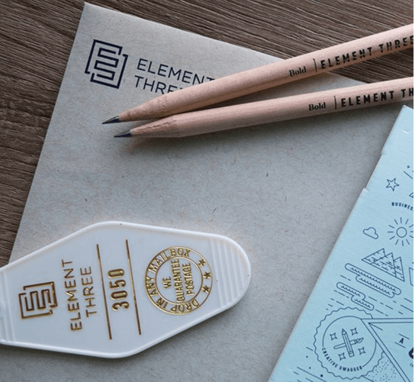 Image of a keychain, two pencils, envelope and small note pade with creative illustrations designed by Bart Fish