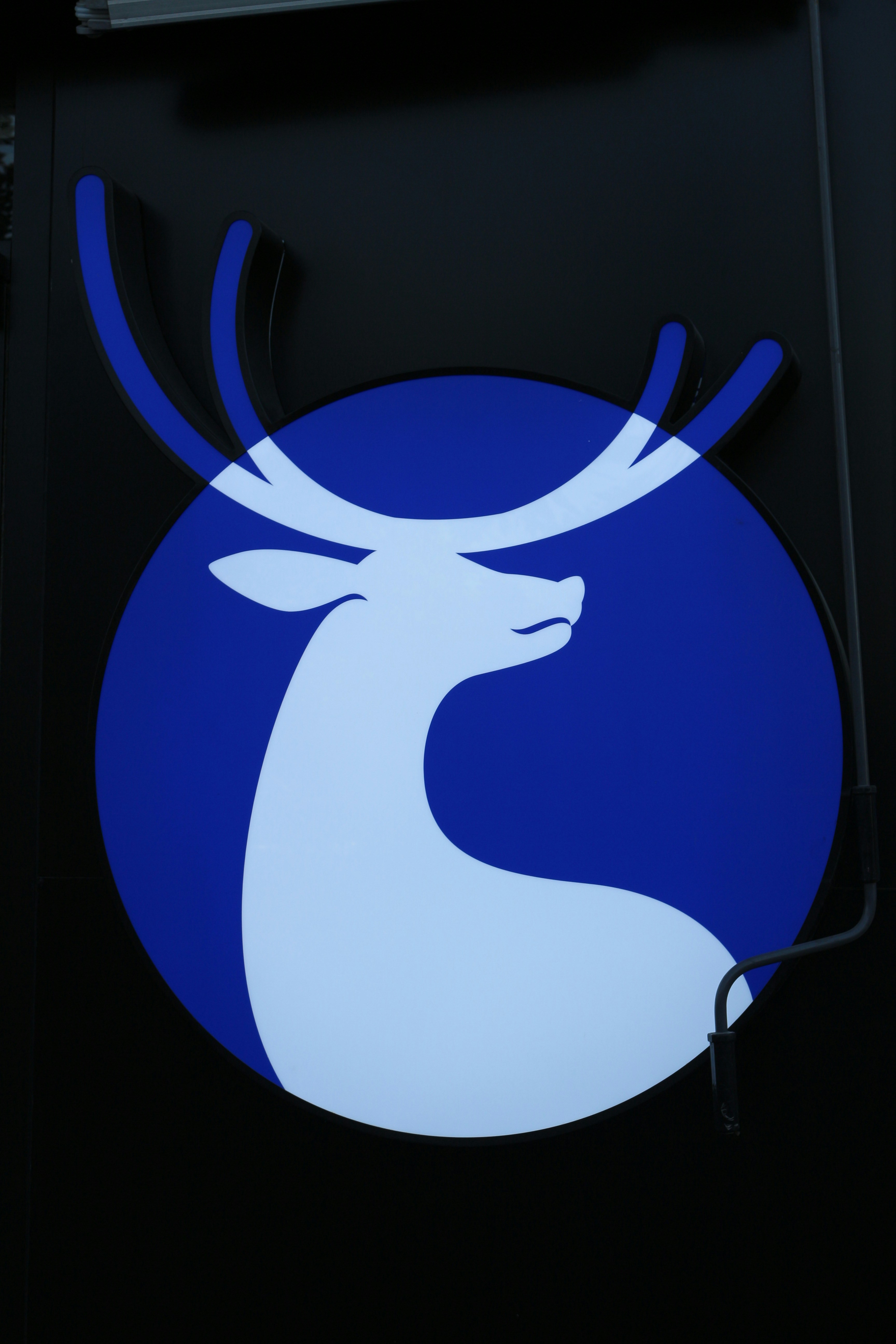 a blue and white deer logo on the side of a building