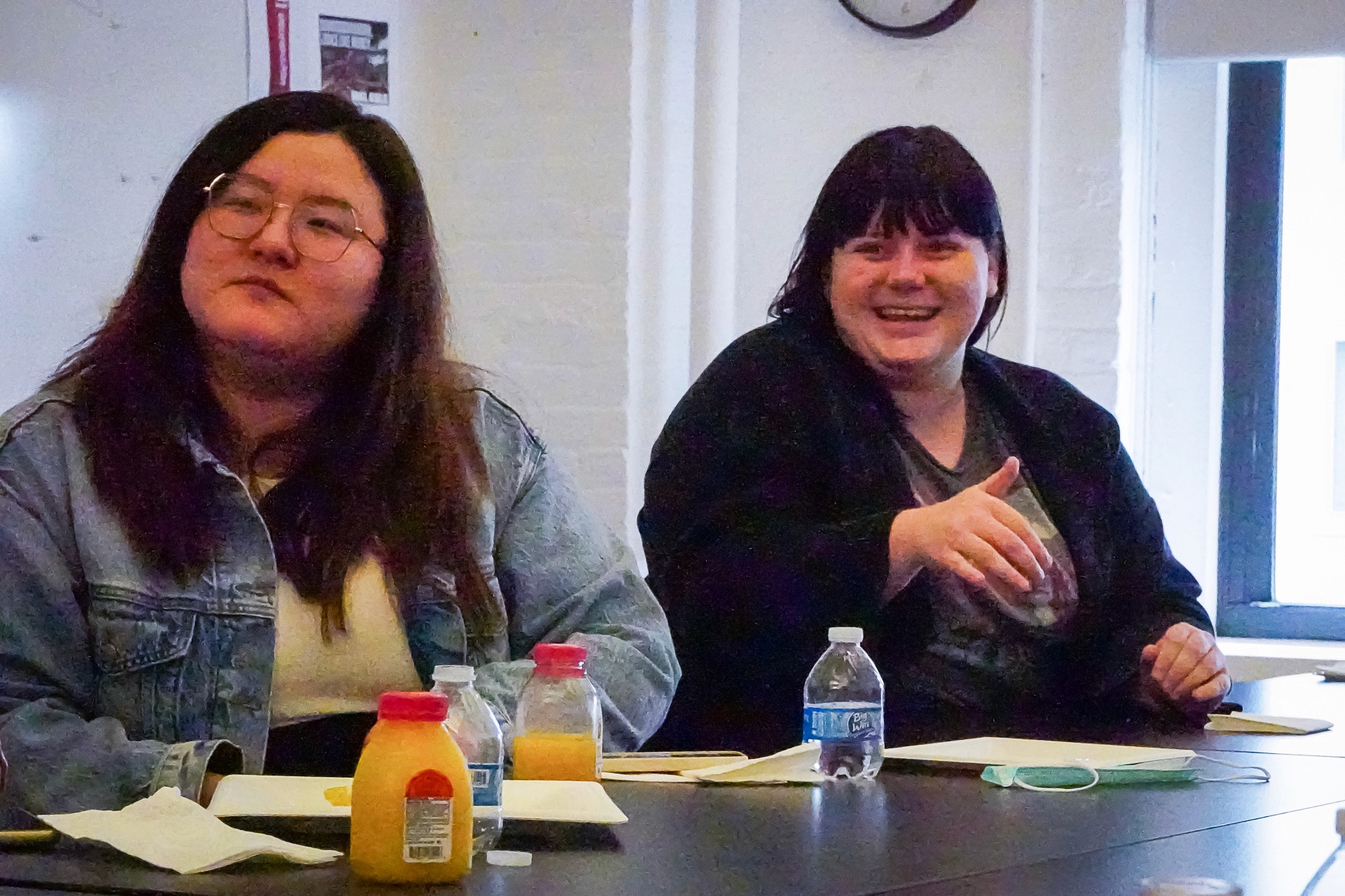 A photo of two women sitting at a desk in an office room.