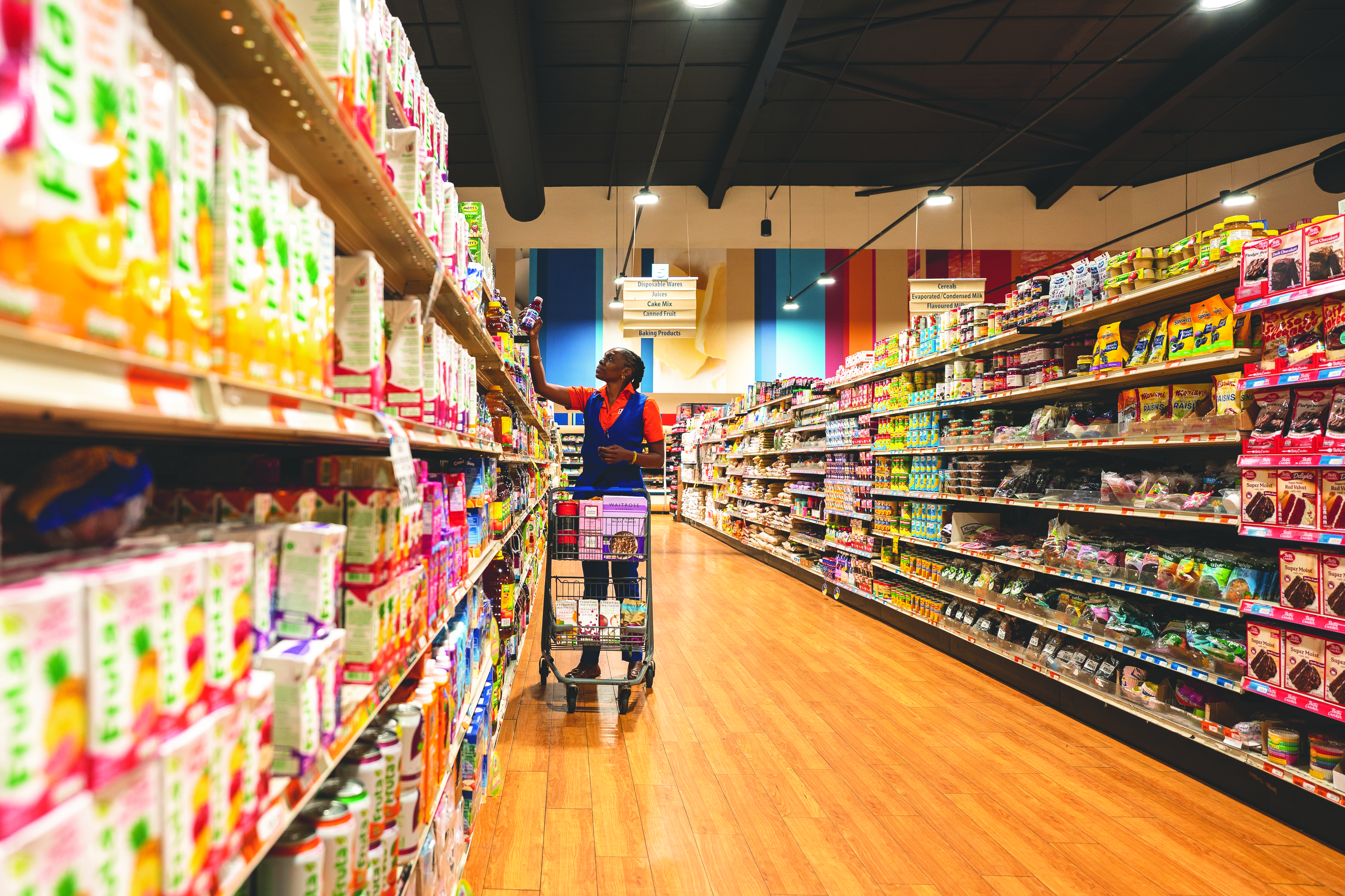 Massy employee replenishing stock on store shelves