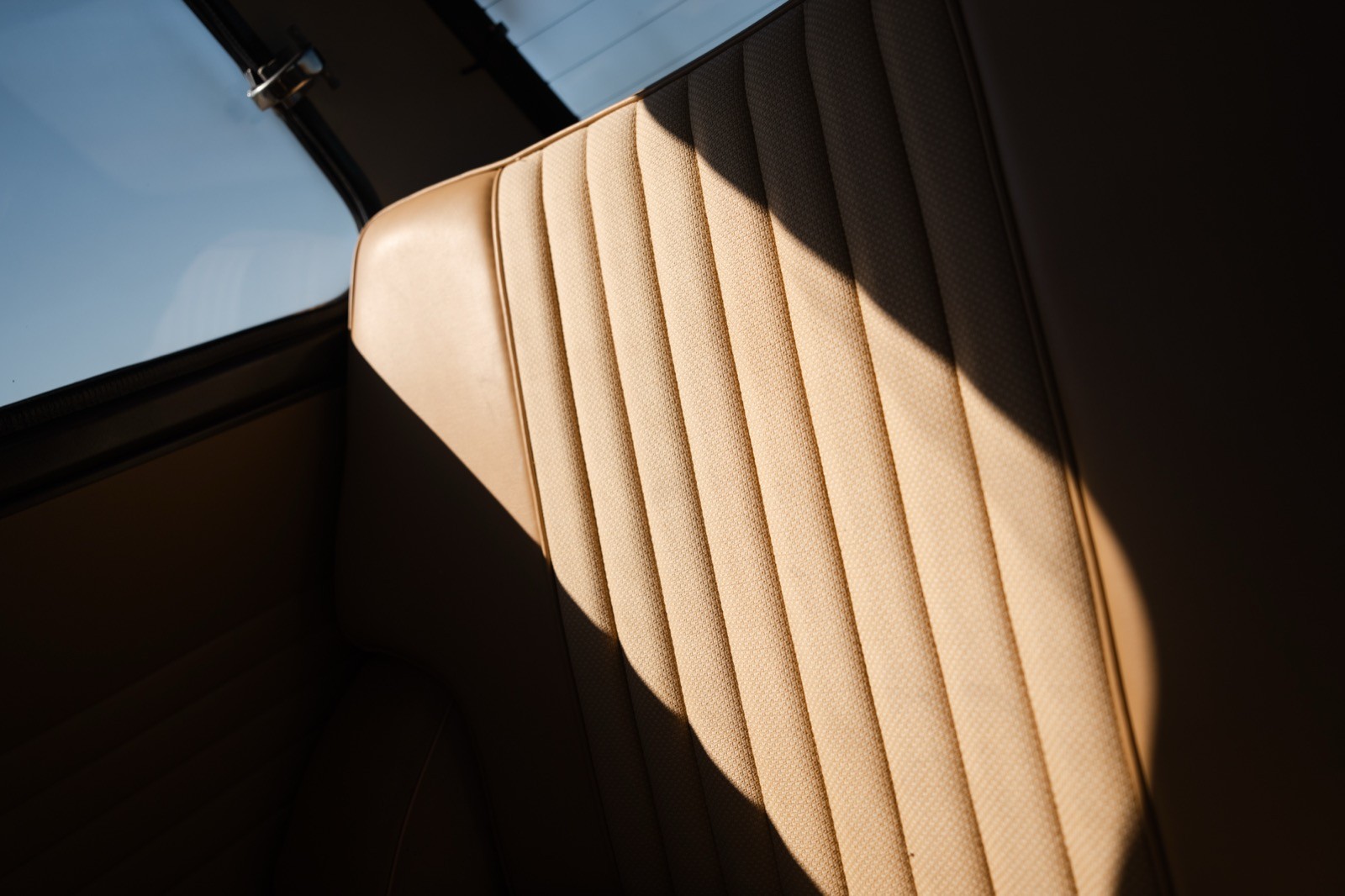 Close-up of a wooden surface with light and shadow creating a striped pattern against a dark background.