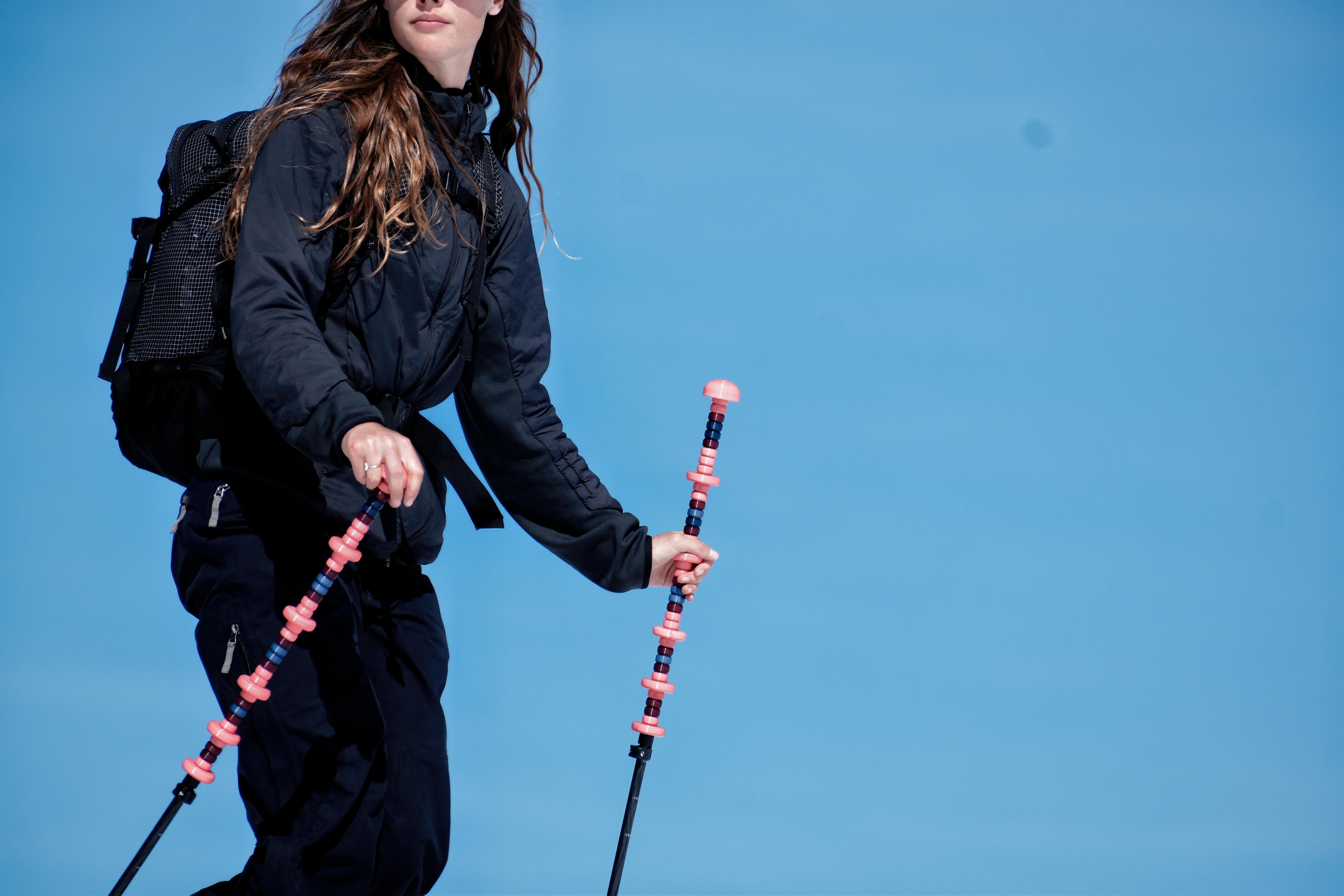 twIIgs push ledge backcountry ski poles held by skier in black jacket against blue sky