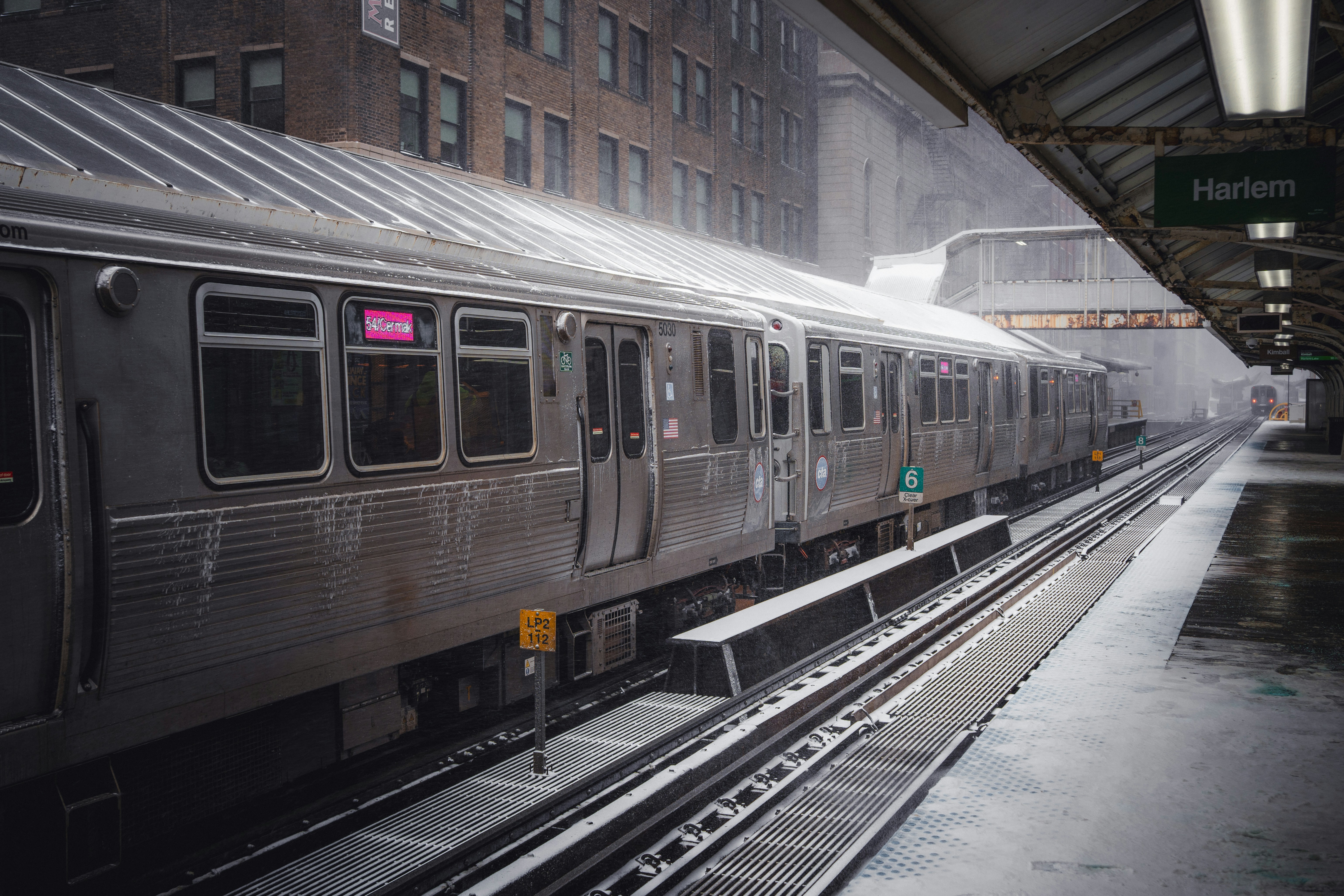A train sits at a snowy station platform.