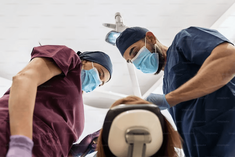 Two dentists preparing a patient for a dental crown procedure