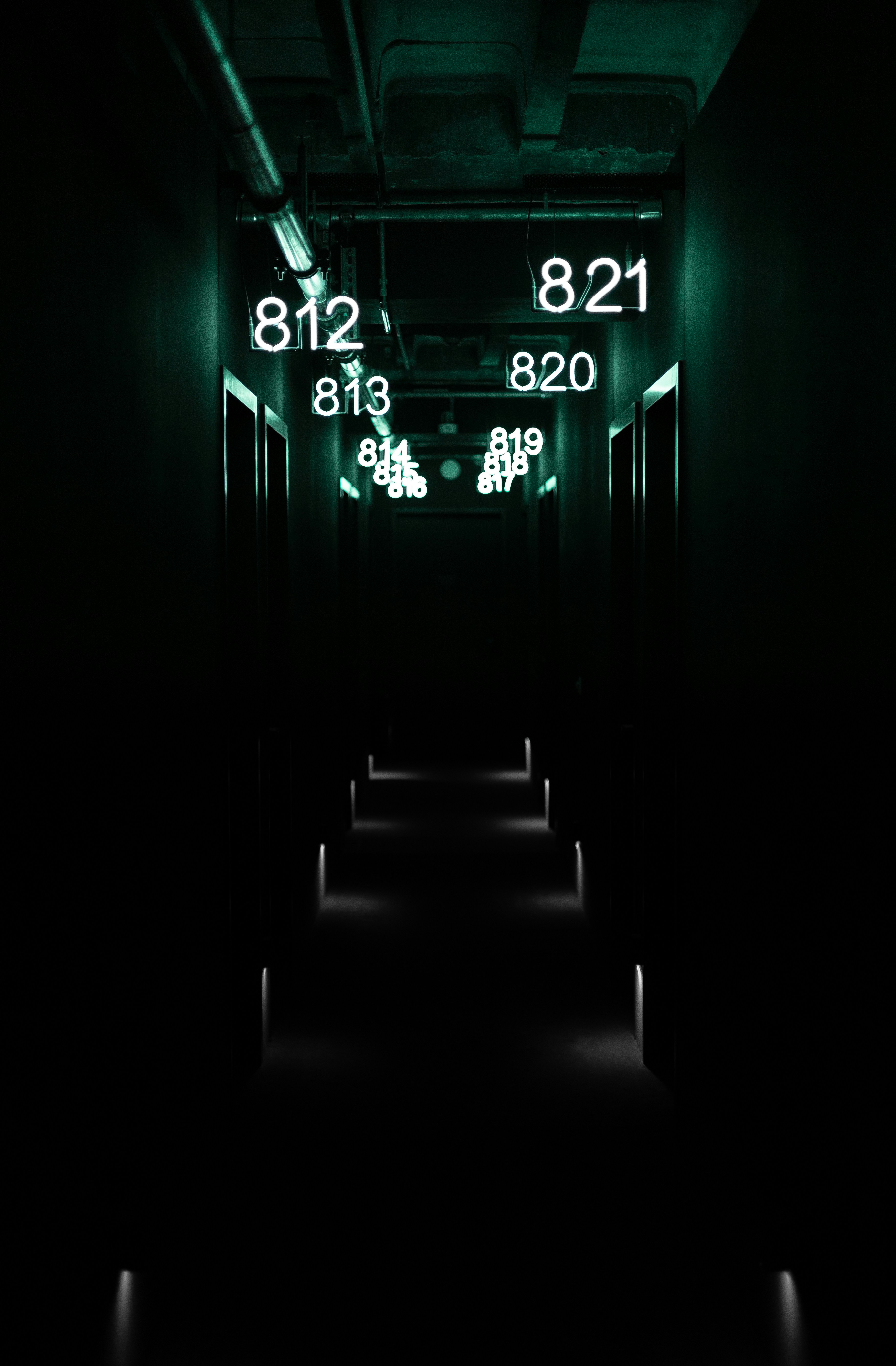 A long dark hallway with a clock on the wall