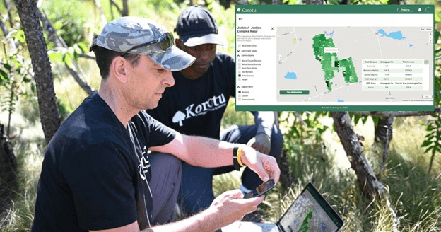 A winding road cuts through rocky terrain, surrounded by patches of green grass and illuminated by sunlight.