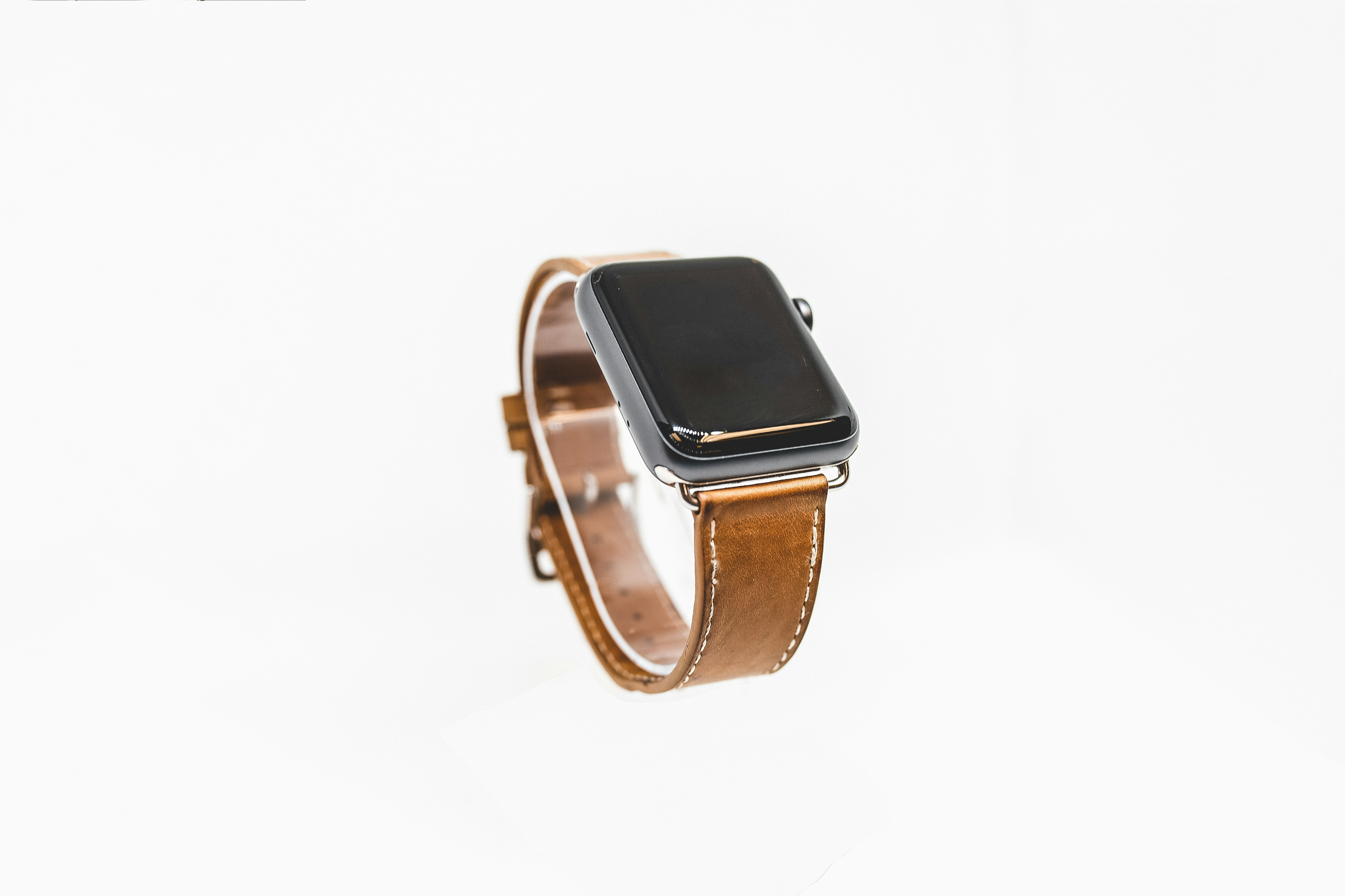 Apple Watch on a brown top-grain leather strap against a clean white background